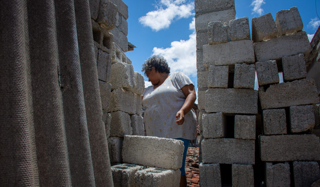 Mujer entre ladrillos construyendo su casa en Cuba