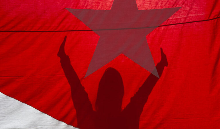 Mujeres y democracia. Una sombra de mujer reflejada en una bandera cubana