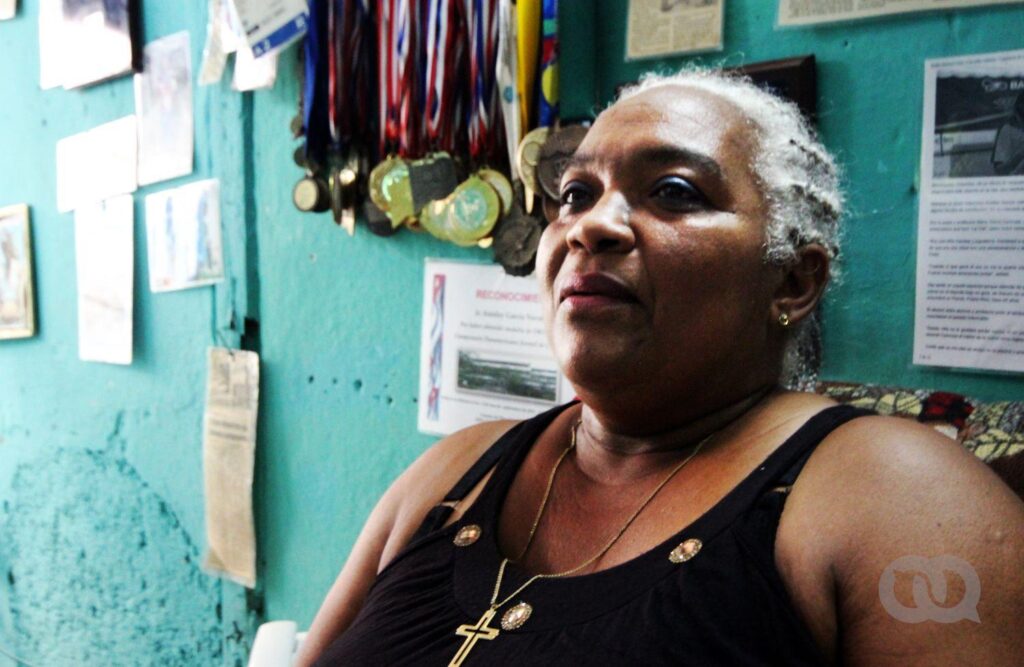 La madre de la clavadista Anisley García Navarro, junto a las medallas de su hija