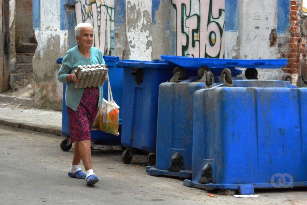 Persona mayor en Cuba camina con la compra del mercado por la calle