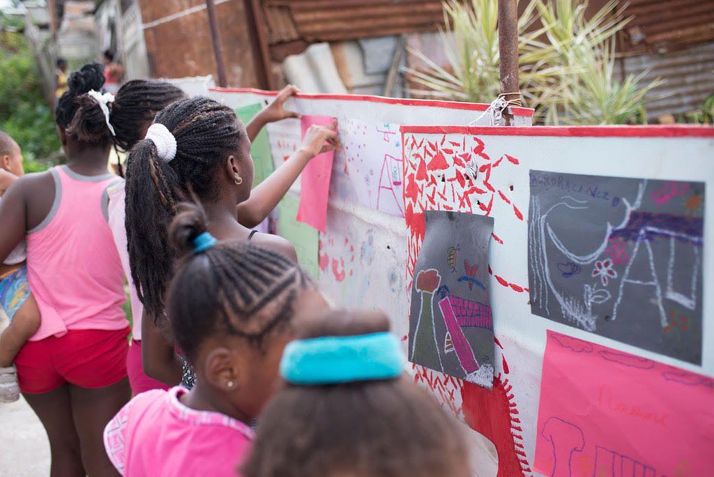 Niñas colocan sus dibujos en murales en el  proyecto Akokán, Los Pocitos. Construyendo ciudad