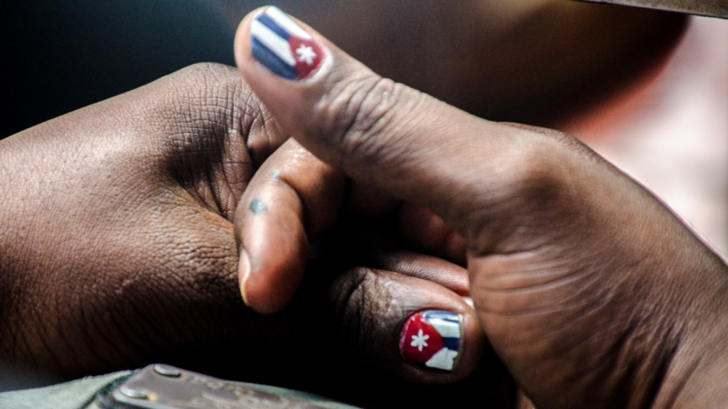 Manos de mujer negra cubana, bandera cubana en uñas, racialidad, ética Cuba