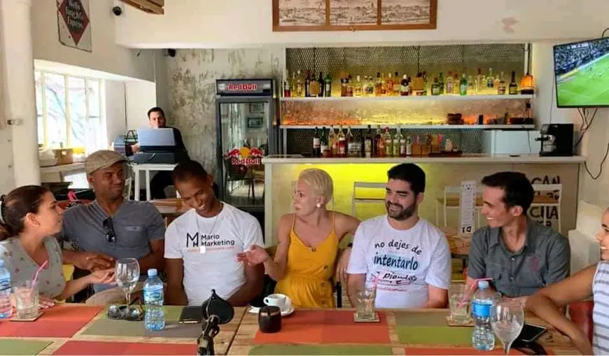 Jóvenes cubanos emprendedores en el sector privado de Cuba. Reunidos en un restaurante conversando sobre sus proyectos 