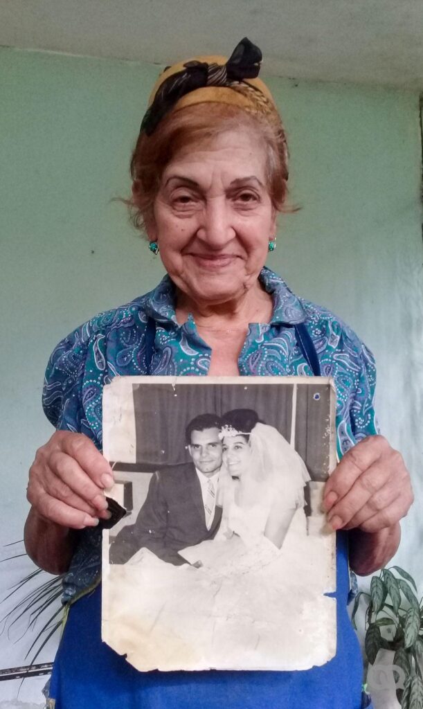 Nela entrevistada en el documental sobre mujeres en la Sierra Maestra. Muestra una fotografía de su boda