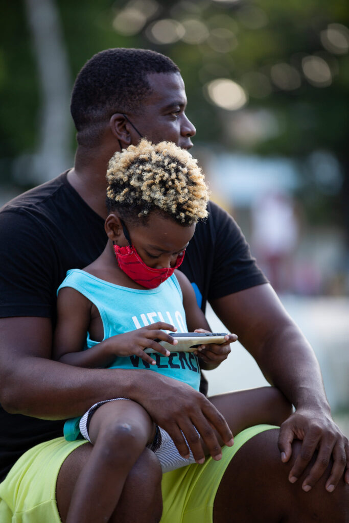 padre con hijo que juega con un teléfono móvil